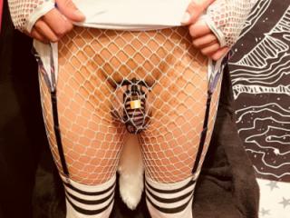 Sissy Slave wearing a black chastity cage and white dress 5 of 15