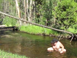 Bathing naked in the creek.