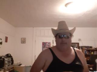 In sunglasses and bra and thong and cowboy hat 5 of 9