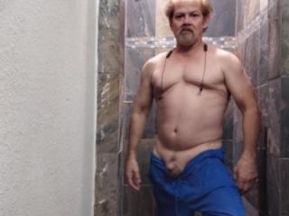 Old guy flexing his small muscle in the shower