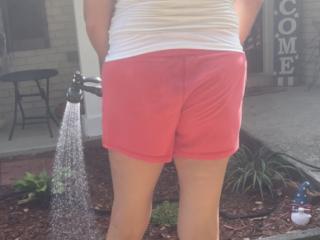 Sexy blonde wife watering her garden 1 of 4