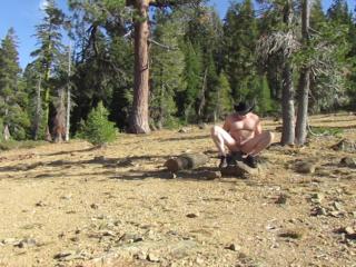 Sitting naked on a rock on top of the mountain.